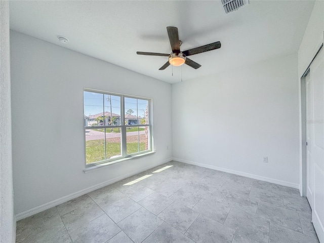 unfurnished room with a ceiling fan, visible vents, and baseboards