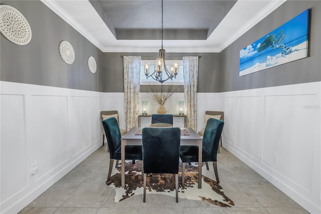 10446 Highland Park Pl, Palmetto, FL 34221 - dining space featuring a decorative wall, a raised ceiling, a chandelier, ornamental molding, and a wainscoted wall