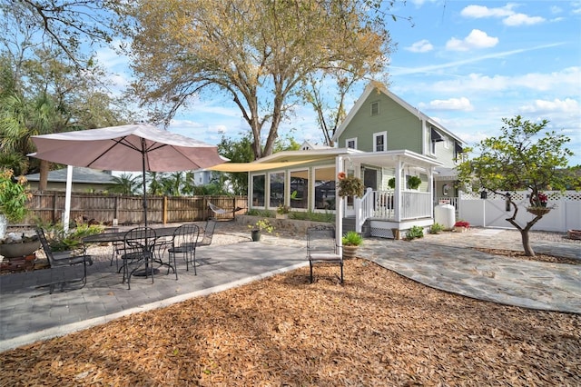 rear view of house with a patio area and fence