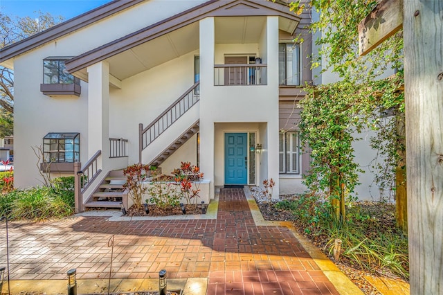 view of front of property featuring stairs and stucco siding