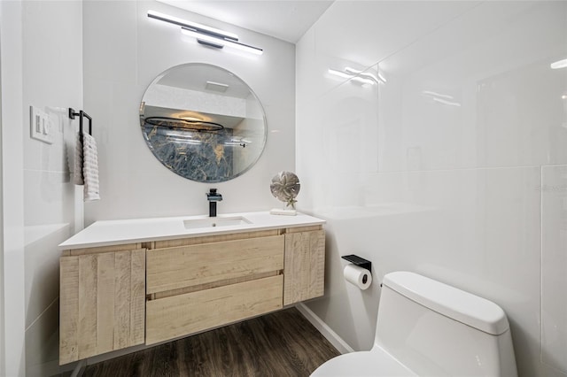 bathroom featuring toilet, wood finished floors, and vanity