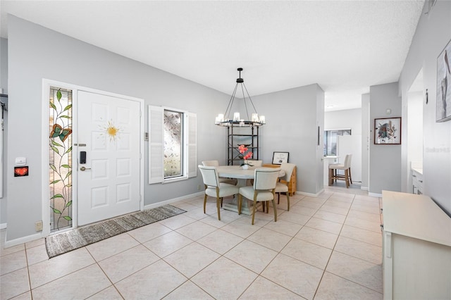 dining area with light tile patterned floors, a chandelier, and baseboards