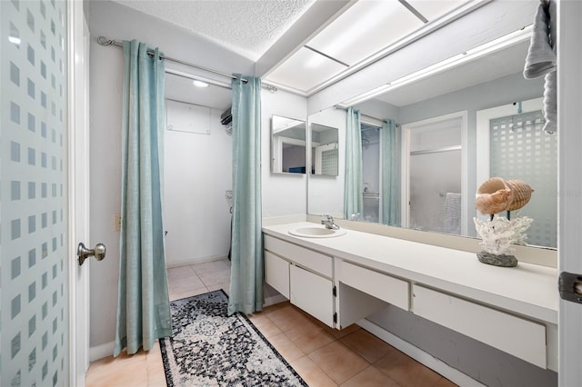 full bath featuring a shower with shower curtain, vanity, a textured ceiling, and tile patterned floors