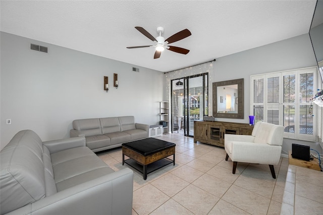 living room featuring light tile patterned floors, plenty of natural light, and visible vents