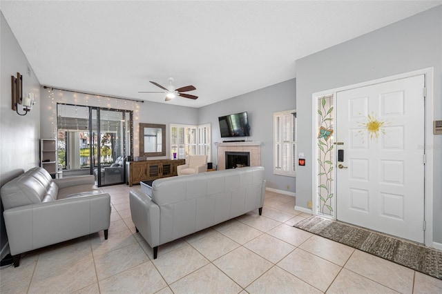 living area with light tile patterned floors, plenty of natural light, baseboards, and a tile fireplace