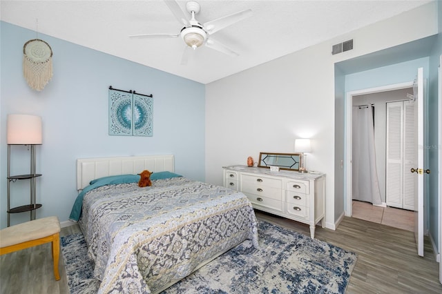 bedroom with visible vents, ceiling fan, a textured ceiling, wood finished floors, and baseboards