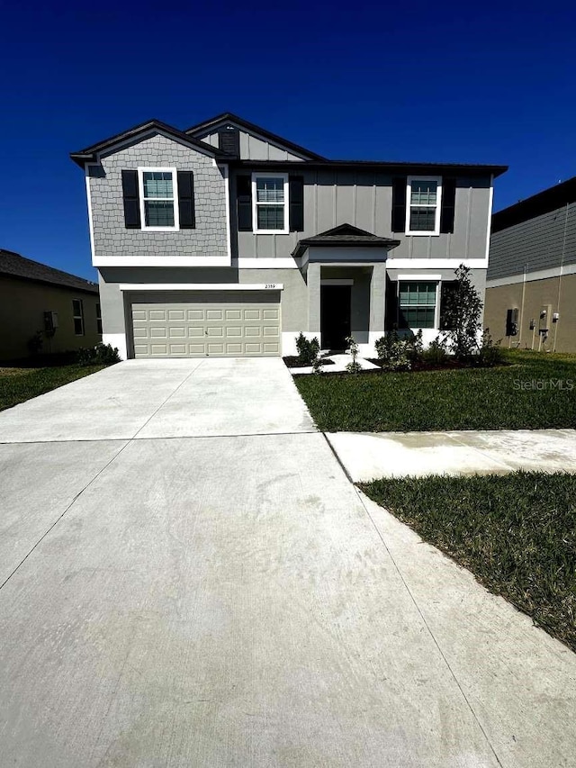 view of front facade with stucco siding, driveway, a garage, and board and batten siding