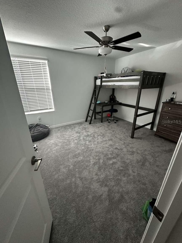 carpeted bedroom with a textured ceiling and ceiling fan