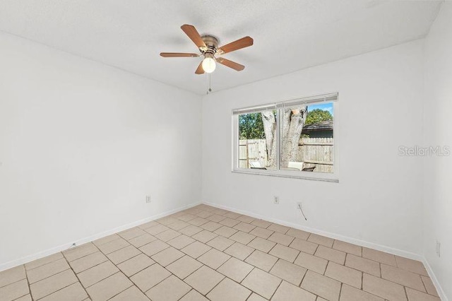 unfurnished room with a ceiling fan and baseboards