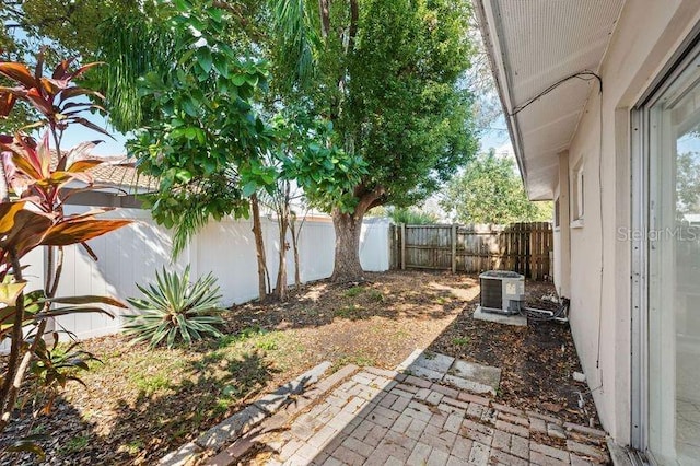 view of yard featuring central air condition unit, a patio area, and a fenced backyard