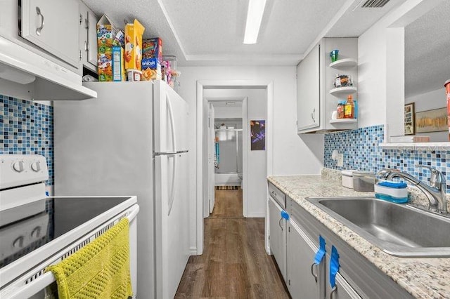 kitchen featuring dark wood-style floors, electric stove, backsplash, a sink, and under cabinet range hood