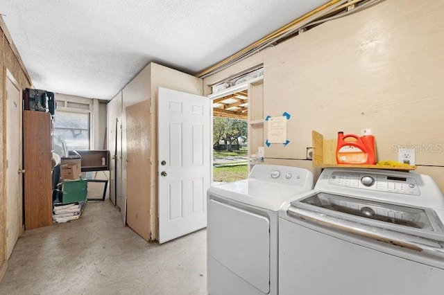 laundry room with a textured ceiling and separate washer and dryer