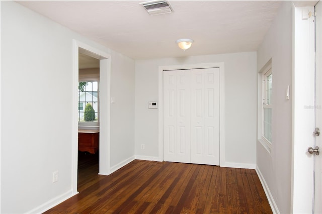 entrance foyer featuring dark wood finished floors, visible vents, and baseboards