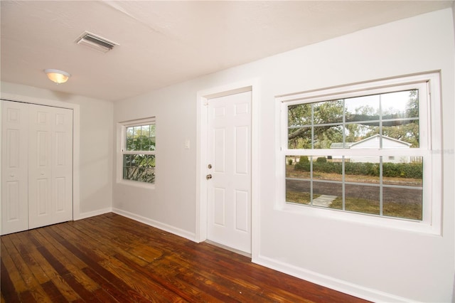 foyer featuring visible vents, dark wood finished floors, and baseboards