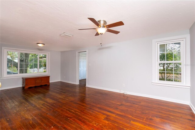 unfurnished room with wood-type flooring, visible vents, a ceiling fan, a textured ceiling, and baseboards