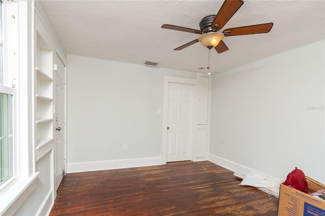 empty room featuring baseboards, a textured ceiling, visible vents, and wood finished floors