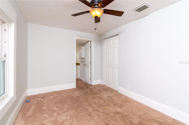 carpeted spare room with baseboards and visible vents