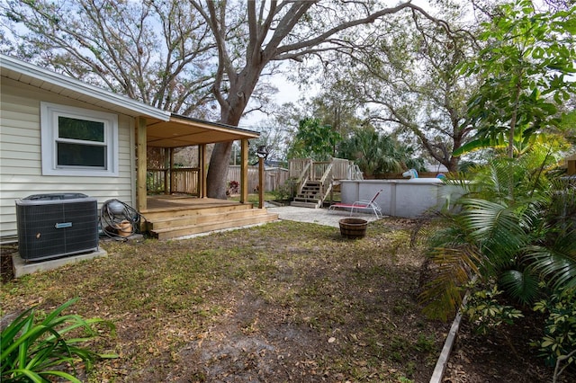 view of yard featuring an outdoor pool, a deck, and central air condition unit