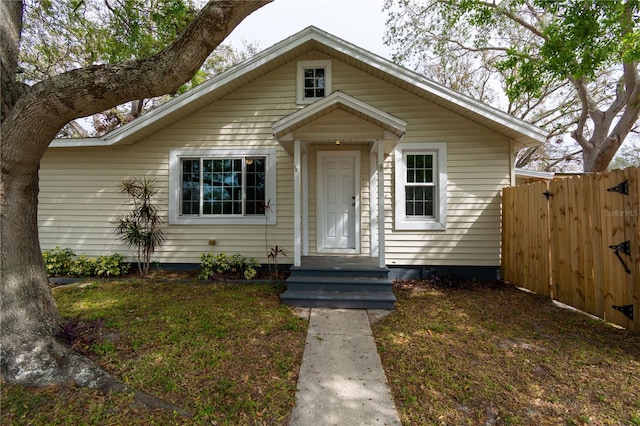 bungalow-style home with entry steps and fence