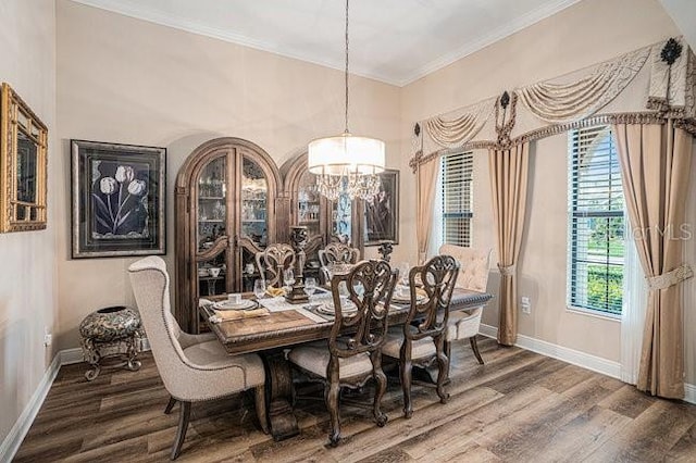 dining room featuring baseboards, wood finished floors, and crown molding