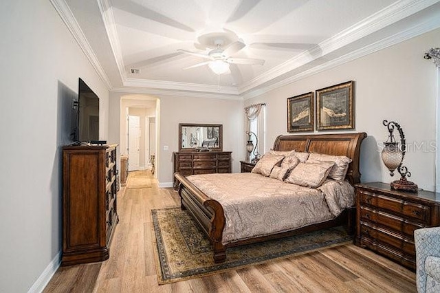 bedroom featuring ornamental molding, light wood-type flooring, ceiling fan, and baseboards