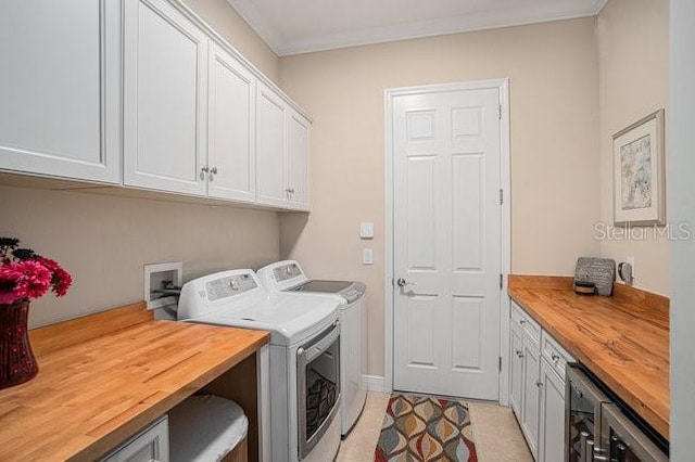 laundry room with ornamental molding, beverage cooler, cabinet space, and separate washer and dryer