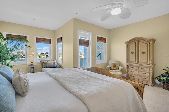 bedroom with access to exterior, a ceiling fan, and carpet flooring