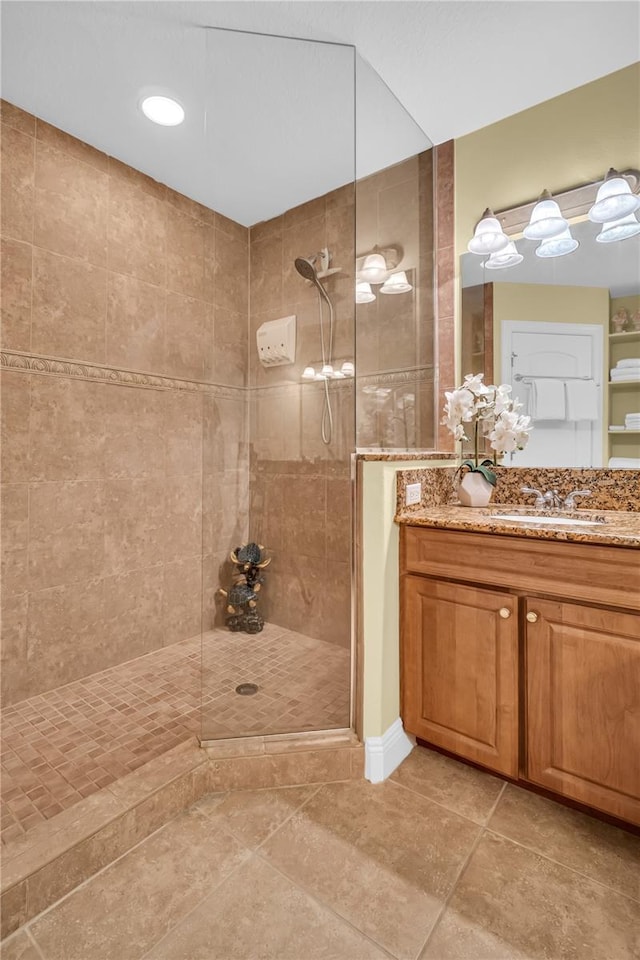 bathroom with a walk in shower, tile patterned flooring, and vanity