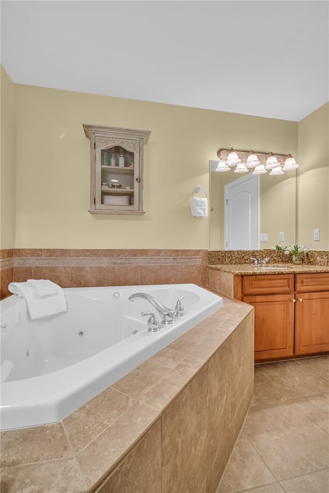 full bath with a whirlpool tub, tile patterned flooring, and vanity