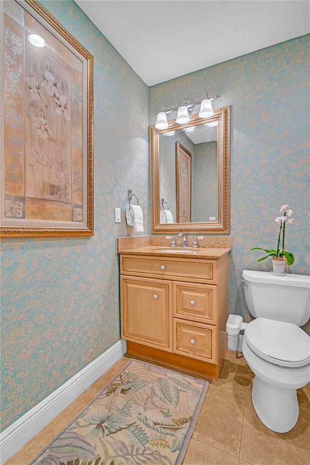 bathroom featuring wallpapered walls, baseboards, toilet, tile patterned flooring, and vanity