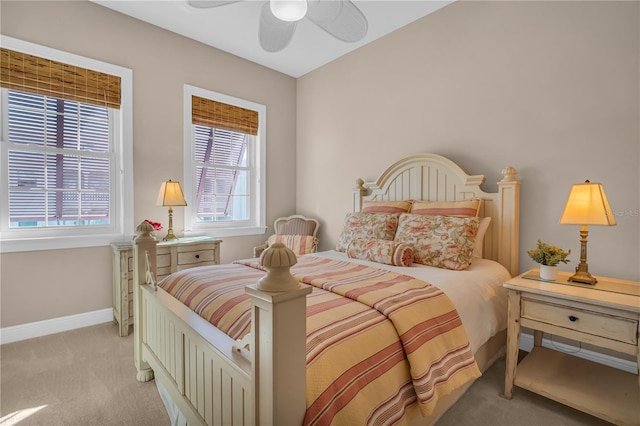 bedroom featuring ceiling fan, baseboards, and light colored carpet