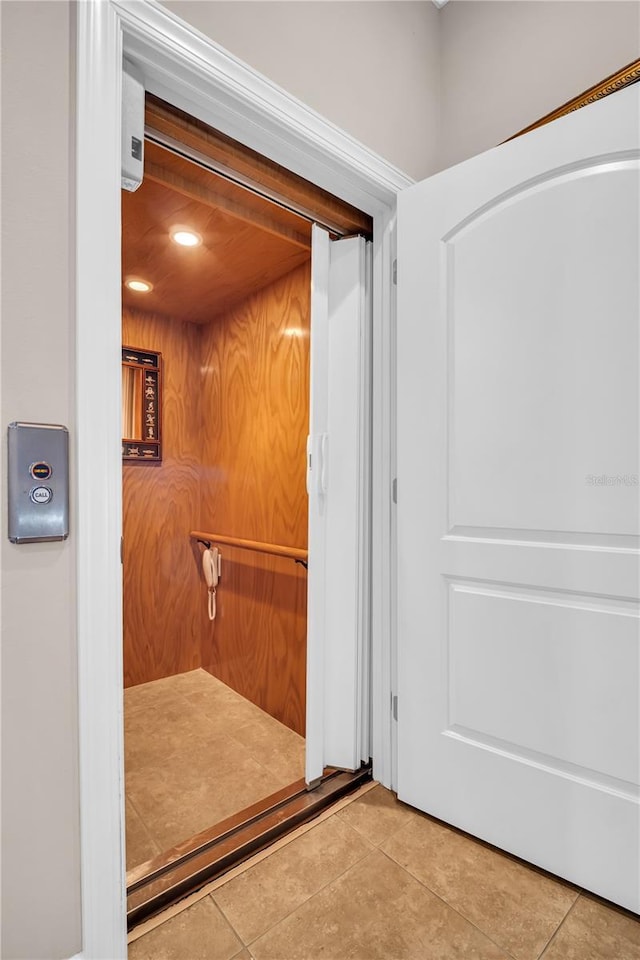 bathroom with elevator and tile patterned flooring