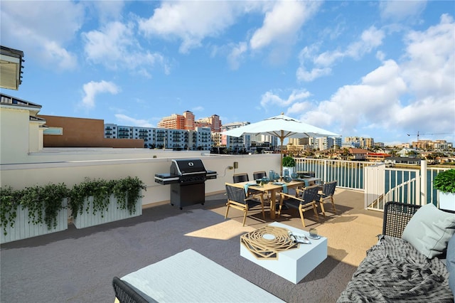 view of patio with a view of city, outdoor dining area, and grilling area