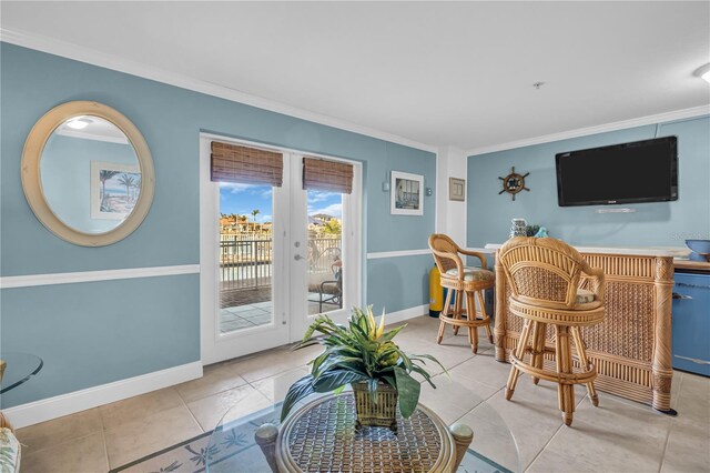 interior space with baseboards, light tile patterned floors, and crown molding