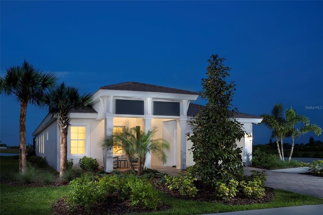 view of front of home with a garage, decorative driveway, and stucco siding