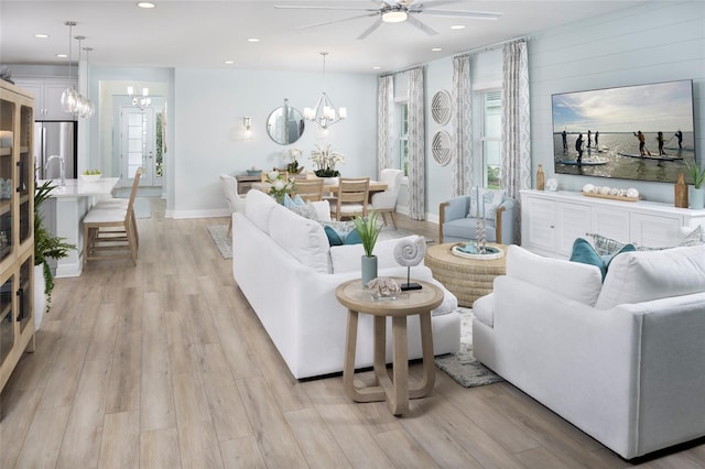 living room featuring recessed lighting, baseboards, and light wood finished floors