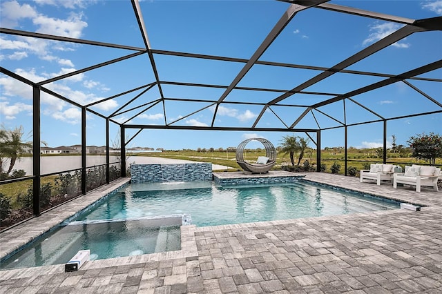 view of pool with glass enclosure, a pool with connected hot tub, and a patio area