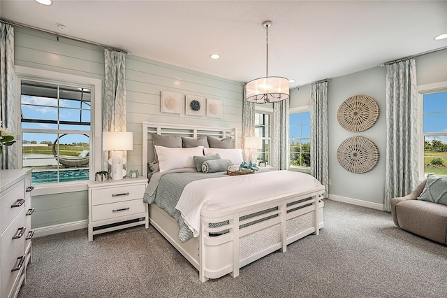 bedroom with recessed lighting, dark carpet, wooden walls, and baseboards