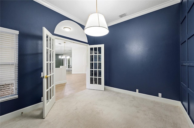 carpeted empty room with french doors, visible vents, crown molding, and baseboards