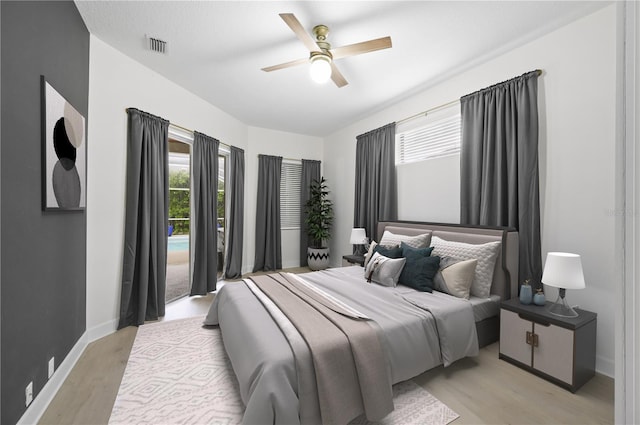 bedroom featuring light wood finished floors, multiple windows, visible vents, and baseboards