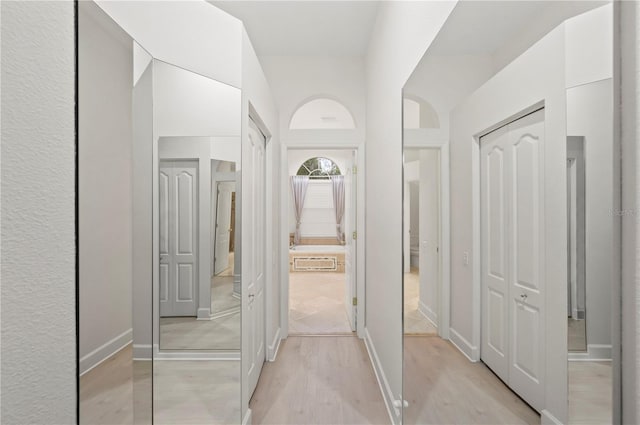 hall featuring light wood finished floors and baseboards