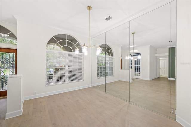 interior space with a wealth of natural light, visible vents, crown molding, and wood finished floors