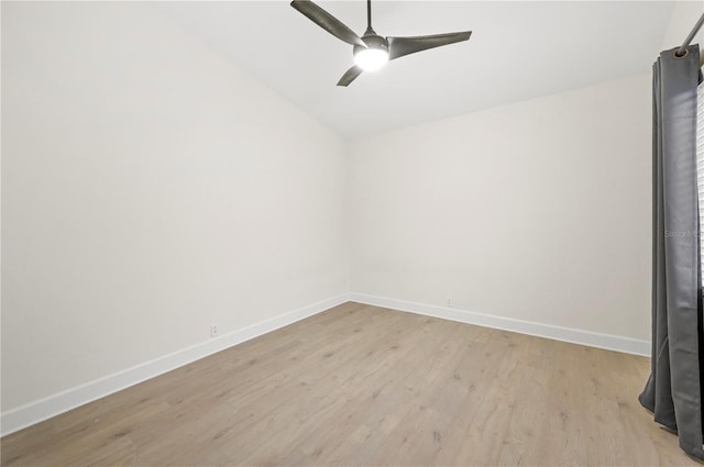 spare room featuring light wood finished floors, baseboards, and a ceiling fan