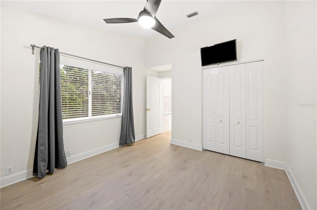 unfurnished bedroom with baseboards, visible vents, a ceiling fan, light wood-style floors, and a closet