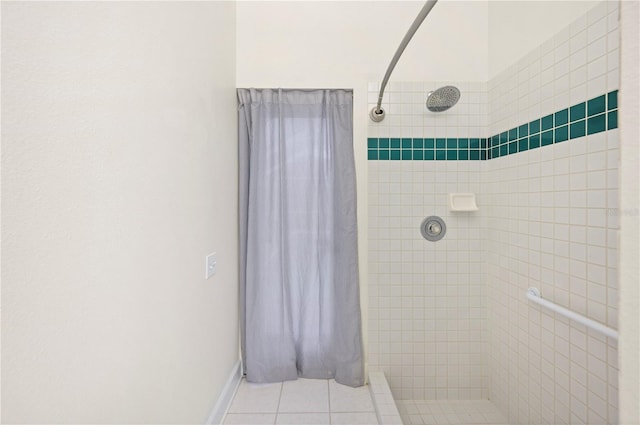 bathroom with a tile shower and tile patterned floors