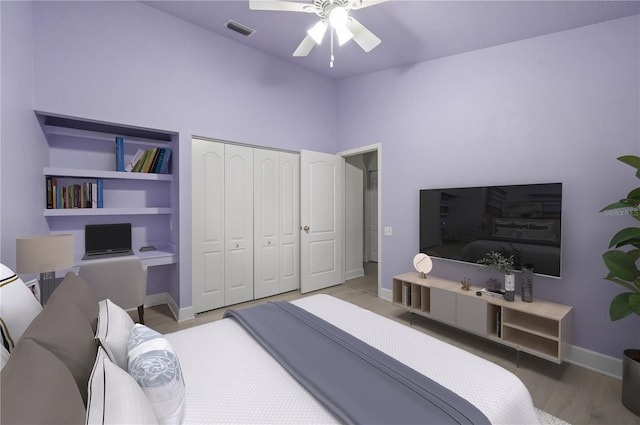 bedroom with baseboards, visible vents, a ceiling fan, wood finished floors, and a closet