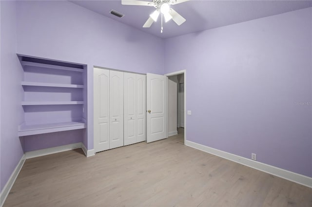 unfurnished bedroom with light wood-style floors, visible vents, ceiling fan, and baseboards