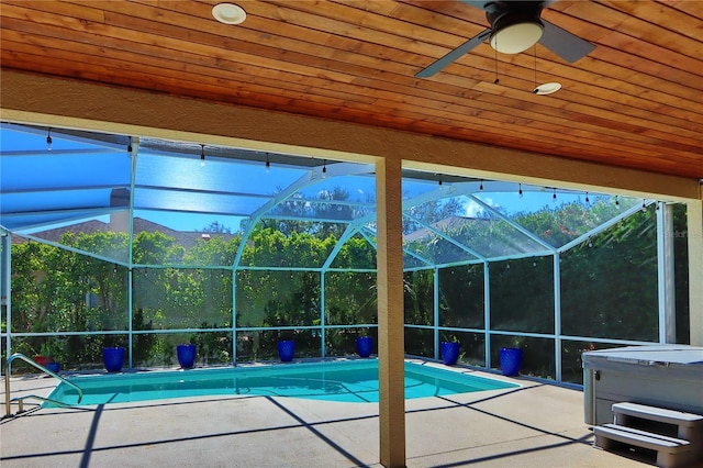 outdoor pool with a lanai, a patio area, and a hot tub