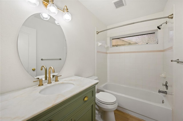 bathroom with washtub / shower combination, visible vents, vanity, and toilet