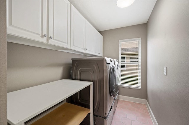 laundry room with cabinet space, washing machine and dryer, a wealth of natural light, and light tile patterned flooring